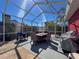 Screened-in patio with dining set and grill, perfect for outdoor entertaining at 1102 Springtime Dr, Holiday, FL 34691