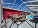 Screened-in patio with dining set overlooking the sparkling pool at 1102 Springtime Dr, Holiday, FL 34691