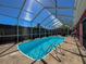 Inviting pool inside a screened enclosure with access to the home's patio at 1102 Springtime Dr, Holiday, FL 34691