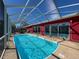 Relaxing covered pool area with clear blue water, ladder access, and deck space for lounging at 1102 Springtime Dr, Holiday, FL 34691