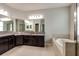 Luxurious bathroom with a soaking tub, granite countertops, dual sinks, and custom cabinetry at 11335 77Th E St, Parrish, FL 34219