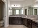Bathroom vanity featuring granite countertop, dark cabinetry, and large mirror at 11335 77Th E St, Parrish, FL 34219