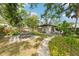 Charming backyard with a brick pathway, dining area, and shed surrounded by lush greenery at 114 E Emily St, Tampa, FL 33603