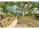 Spacious backyard with a brick pathway, mature trees, a shed, and outdoor seating area at 114 E Emily St, Tampa, FL 33603