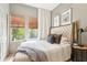 This bedroom has wood floors, natural-colored walls, and a bed with grey, white, and brown striped bedding at 114 E Emily St, Tampa, FL 33603