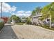 Exterior view featuring a gravel driveway leading to a well-kept home and yard at 114 E Emily St, Tampa, FL 33603