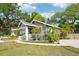 Charming home exterior surrounded by mature trees and lush landscaping at 114 E Emily St, Tampa, FL 33603