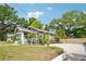 Well-maintained home with mature trees and landscaping, complemented by a gravel driveway at 114 E Emily St, Tampa, FL 33603