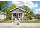 Charming gray home showcasing lush landscaping, manicured lawn, and a welcoming front entryway at 114 E Emily St, Tampa, FL 33603