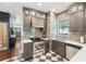 The kitchen has stainless steel appliances, wooden cabinetry, and a window with a vintage pane above the sink at 114 E Emily St, Tampa, FL 33603