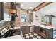 The kitchen has stainless steel appliances, wooden cabinetry, and a window with a vintage pane above the sink at 114 E Emily St, Tampa, FL 33603
