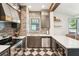 The kitchen has stainless steel appliances, wooden cabinetry, and a window with a vintage pane above the sink at 114 E Emily St, Tampa, FL 33603