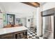 The kitchen has stainless steel appliances and a counter with two leather chairs at a bar with a checkered tile floor at 114 E Emily St, Tampa, FL 33603