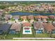 Aerial view of a lakefront neighborhood with many houses featuring backyard pools and community amenities at 11966 Climbing Fern Ave, Riverview, FL 33579
