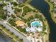 Aerial view of community amenities including a pool, clubhouse, park and playground all located near a scenic lake at 11966 Climbing Fern Ave, Riverview, FL 33579
