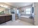 Bright bathroom featuring granite countertop, dark cabinets, shower and soaking tub at 11966 Climbing Fern Ave, Riverview, FL 33579