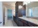 Bathroom with granite countertops, dark cabinets, and tile flooring leading to the bedroom at 11966 Climbing Fern Ave, Riverview, FL 33579