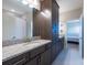 Bathroom featuring granite countertop, dark cabinets and a shower curtain with a forest print at 11966 Climbing Fern Ave, Riverview, FL 33579