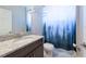 Bathroom featuring granite countertop, vanity cabinet and a shower curtain with a forest print at 11966 Climbing Fern Ave, Riverview, FL 33579