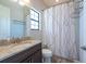 Bright bathroom with granite countertop, and tub-shower combo with modern curtain at 11966 Climbing Fern Ave, Riverview, FL 33579