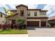 Beautiful two-story home featuring stone accents, a three-car garage, and a well-manicured lawn with palm trees at 11966 Climbing Fern Ave, Riverview, FL 33579