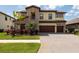Stunning two-story home with a three-car garage, manicured landscaping, and a beautiful brick driveway at 11966 Climbing Fern Ave, Riverview, FL 33579