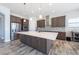 Modern kitchen with stainless steel appliances, a large island with a sink, and wooden floors at 11966 Climbing Fern Ave, Riverview, FL 33579