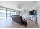 Inviting living room featuring a modern ceiling fan, sliding glass doors to the backyard, and a staircase to the second floor at 11966 Climbing Fern Ave, Riverview, FL 33579