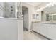 Spacious bathroom with double sinks, granite countertops, a glass-enclosed shower, and neutral tiling at 12379 Amica Loop, Venice, FL 34293