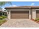 Spacious two-car garage with paved driveway and manicured landscaping at 12379 Amica Loop, Venice, FL 34293