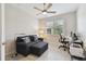 Well-lit home office with modern ceiling fan, desk, love seat, and gray tiled flooring at 12379 Amica Loop, Venice, FL 34293
