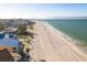 Serene aerial view highlighting beachfront homes bordering a pristine shoreline and tranquil ocean at 12512 1St W St # 2, Treasure Island, FL 33706