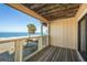 Balcony view framed by rustic wooden ceiling, overlooking the sandy beach and ocean at 12512 1St W St # 2, Treasure Island, FL 33706
