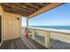 Charming covered balcony with wood railings overlooking the sandy beach at 12512 1St W St # 2, Treasure Island, FL 33706
