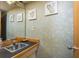Bathroom with a black countertop, tiled sink and decorative, leaf-patterned wall art at 12512 1St W St # 2, Treasure Island, FL 33706