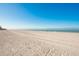 Expansive beach with white sand and clear blue skies offers a serene coastal setting at 12512 1St W St # 2, Treasure Island, FL 33706