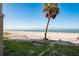 Beautiful beach view from the property featuring clear skies, white sand, and a single palm tree at 12512 1St W St # 2, Treasure Island, FL 33706