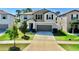 Charming two-story home featuring a well-manicured lawn, lush landscaping, and attached two-car garage at 12841 Wildflower Meadow Dr, Riverview, FL 33579