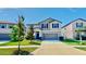Charming two-story home with a well-manicured lawn, a two-car garage, and lush landscaping at 12841 Wildflower Meadow Dr, Riverview, FL 33579