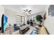 Cozy living room featuring comfortable seating, modern ceiling fan, bright window, and dedicated desk area at 12841 Wildflower Meadow Dr, Riverview, FL 33579