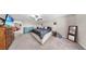 Open main bedroom features a bed, dresser and mirror complemented by neutral tones at 12841 Wildflower Meadow Dr, Riverview, FL 33579