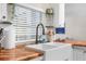 Modern sink and wooden countertop with white window blinds at 13501 Whitby Rd, Hudson, FL 34667