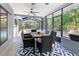 Sunroom featuring an outdoor dining set overlooking a pool and lush landscaping at 13501 Whitby Rd, Hudson, FL 34667