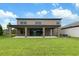 Home exterior showcasing a spacious backyard, covered patio, and lush green lawn at 14403 Woodland Spur Dr, Lithia, FL 33547