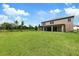 Expansive backyard featuring lush green grass and a covered patio, perfect for outdoor entertaining at 14403 Woodland Spur Dr, Lithia, FL 33547