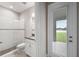 Well-lit bathroom with a tiled shower, modern fixtures, and direct access to the outdoor patio at 14403 Woodland Spur Dr, Lithia, FL 33547