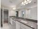 Bright bathroom featuring a double sink vanity with granite countertops, large mirror, and tiled floors at 14403 Woodland Spur Dr, Lithia, FL 33547