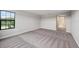 Spacious bedroom with plush carpeting, neutral walls, and a large window offering scenic views at 14403 Woodland Spur Dr, Lithia, FL 33547