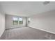 Spacious bedroom featuring three large windows and neutral gray carpet at 14403 Woodland Spur Dr, Lithia, FL 33547