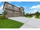 Beautiful home boasts a three-car garage, a well manicured lawn, and ample driveway space at 14403 Woodland Spur Dr, Lithia, FL 33547